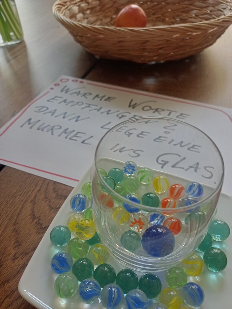 "Warme Worte empfangen? Dann lege eine Murmel ins Glas." Eine Installation zum Welttag des Glücks