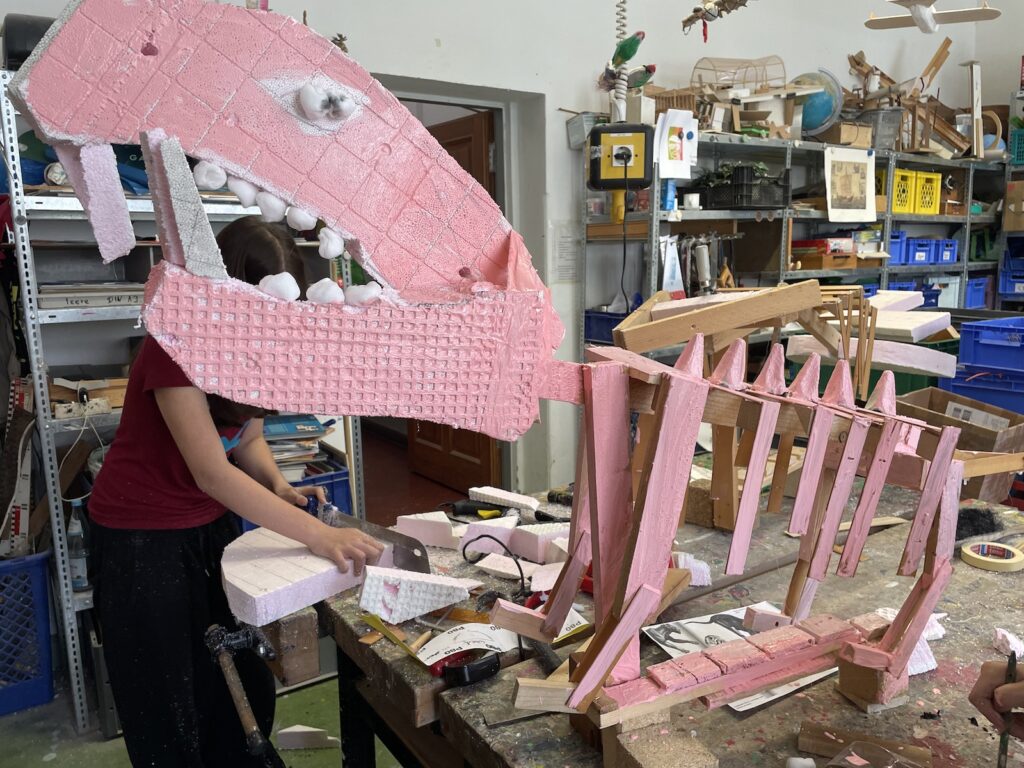 Ein rosa Dinosaurier wird in der Bauwerkstatt kreiert